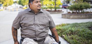 Hispanic American Veteran in a wheelchair. He is a double amputee.