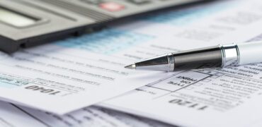 Tax forms close up with a pen and calculator