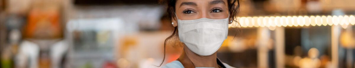 Waitress working at a restaurant wearing a facemask to avoid the spread of COVID-19