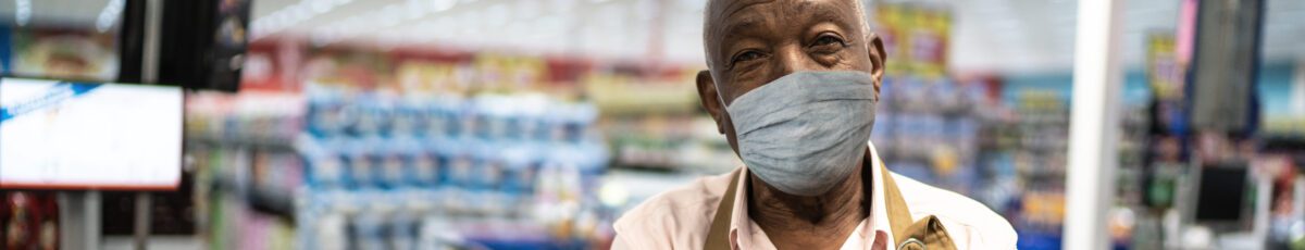 Senior employee with face mask at supermarket