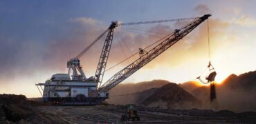 Large mining equipment on a hillside at sunset