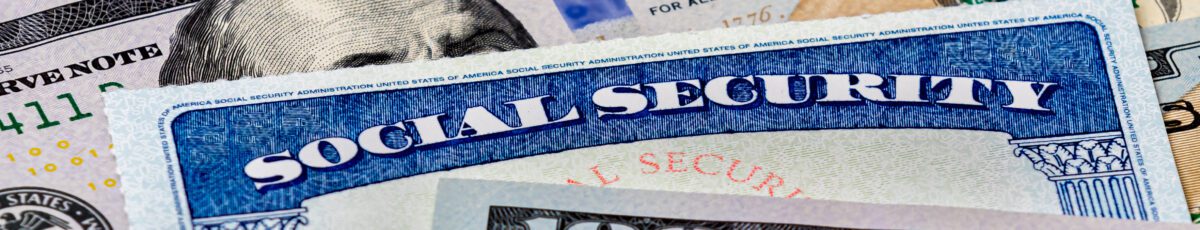 Closeup of social security benefits identification card with 100 dollar bills
