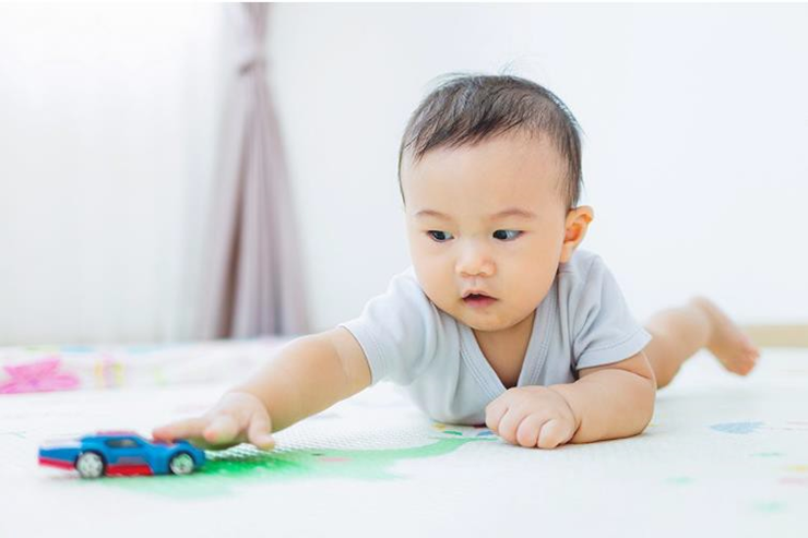 baby playing with a toy car