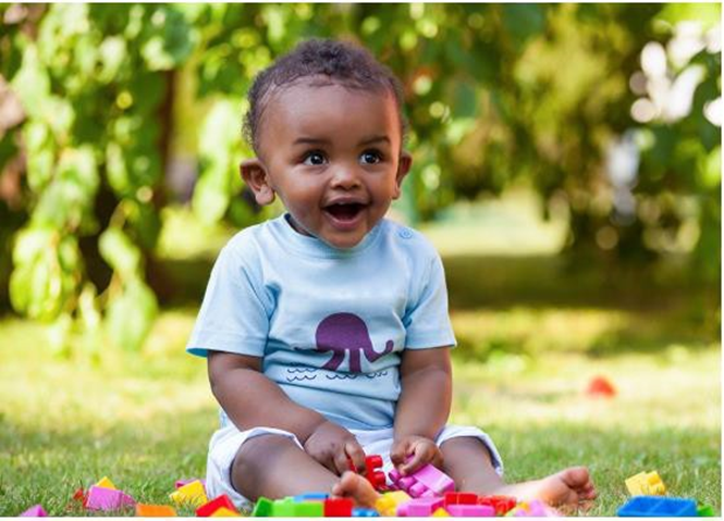 boy playing with blocks on the grass