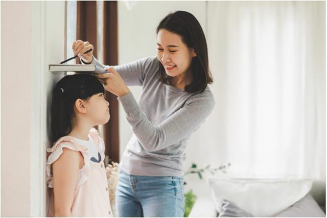 mom measuring daughter's height