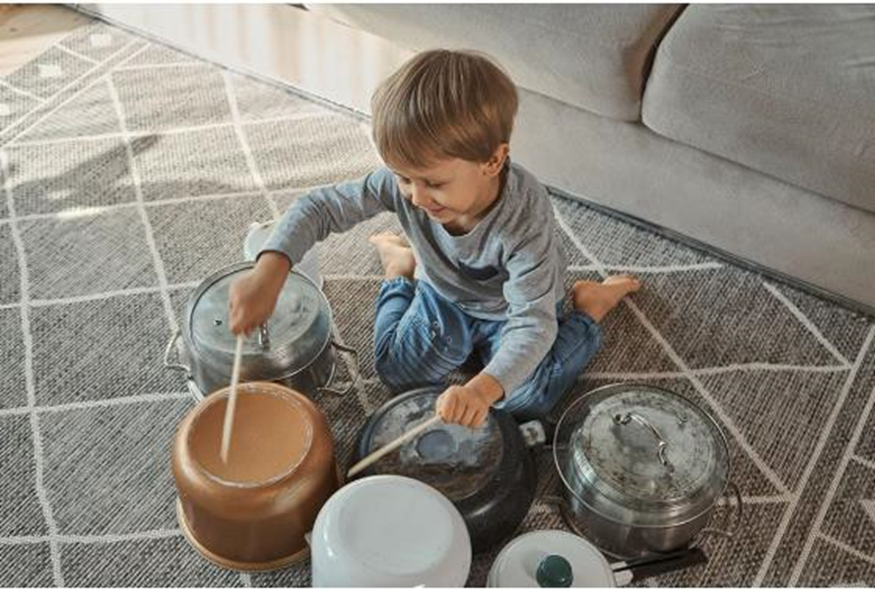 boy playing drums on pots and pans