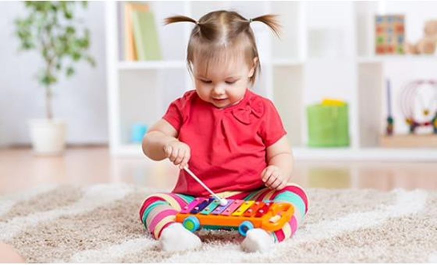 girl playing a toy xylophone