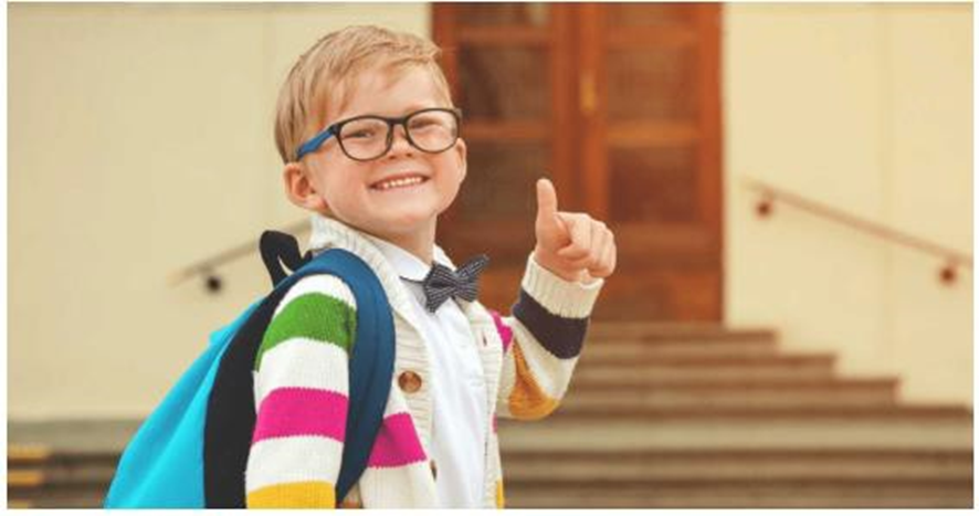 smiling boy with a backpack giving a thumbs up