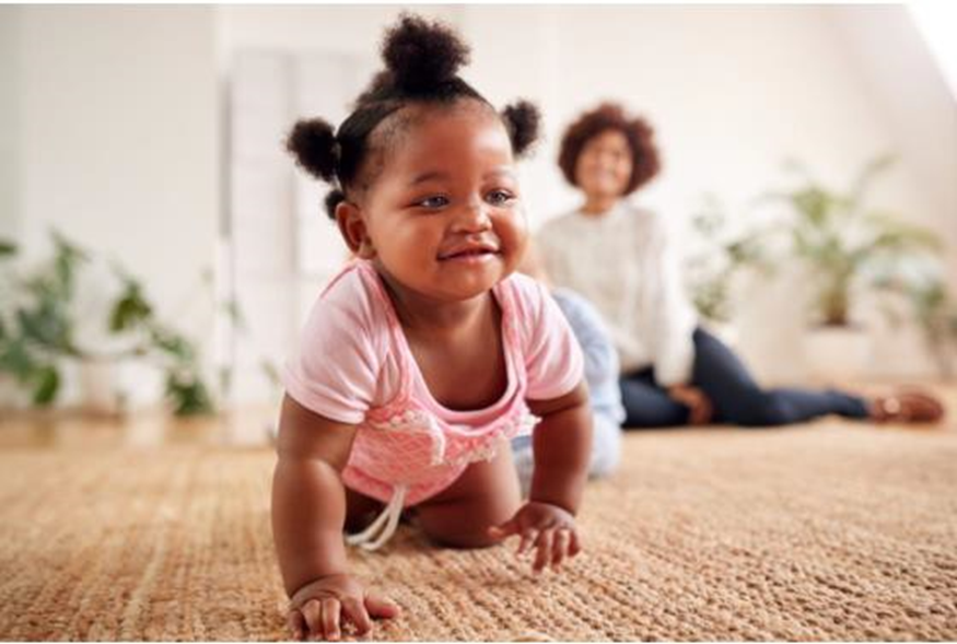 baby crawling while mom watches behind