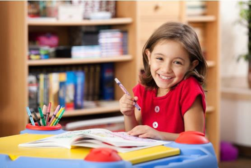 girl smiling and holding a pen