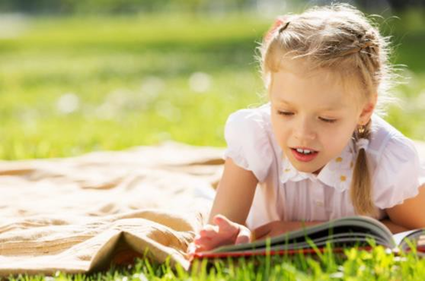 girl on the grass reading a book