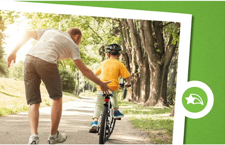 dad teaching boy how to ride a bike
