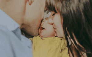 parents kissing baby