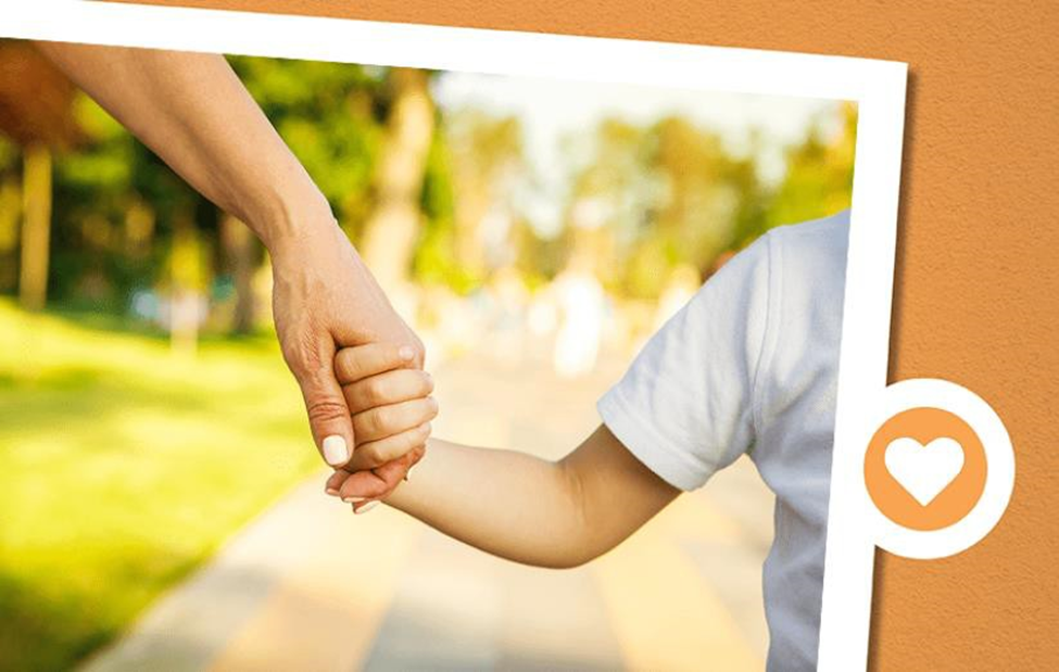 parent holding a child's hand as they walk together