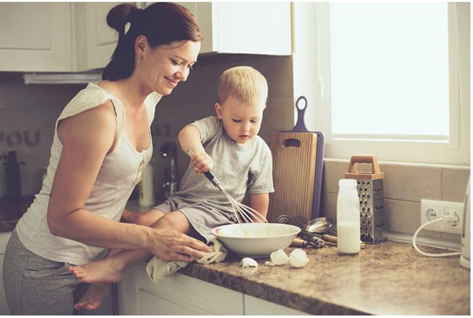 child helping his mom prep on the kitchen counter