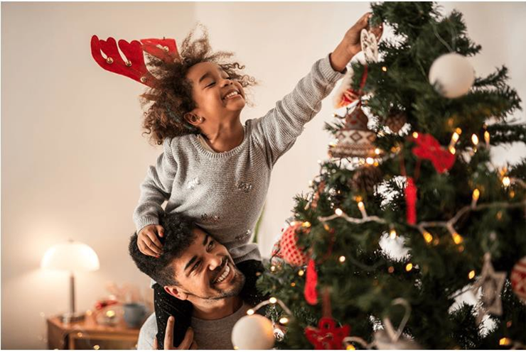 dad and daughter decorating a christmas tree