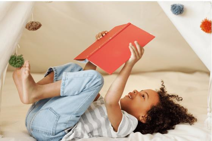 girl in bed reading a book