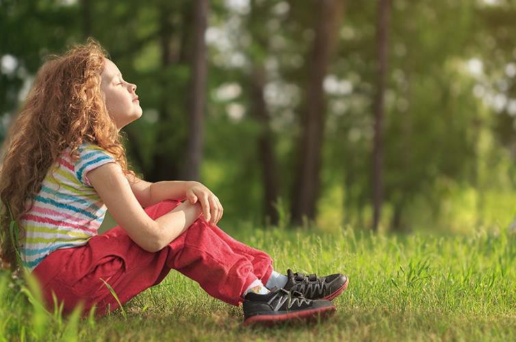 girl sitting on the grass with her eyes closed