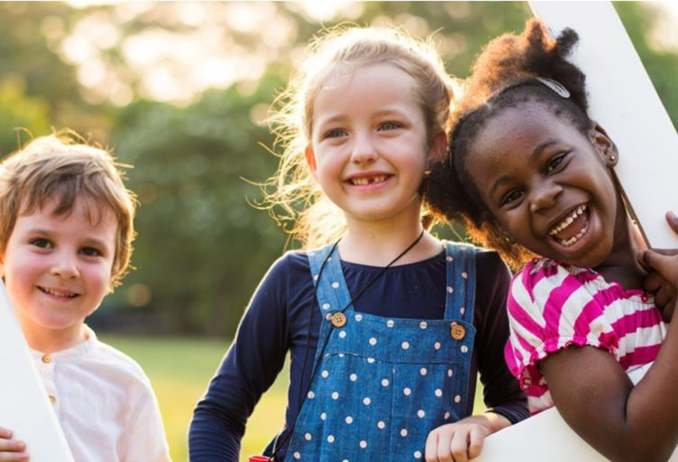 a boy and 2 girls smiling for the camera