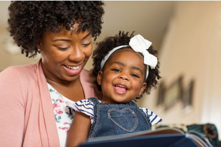mom reading to her child. both are smiling
